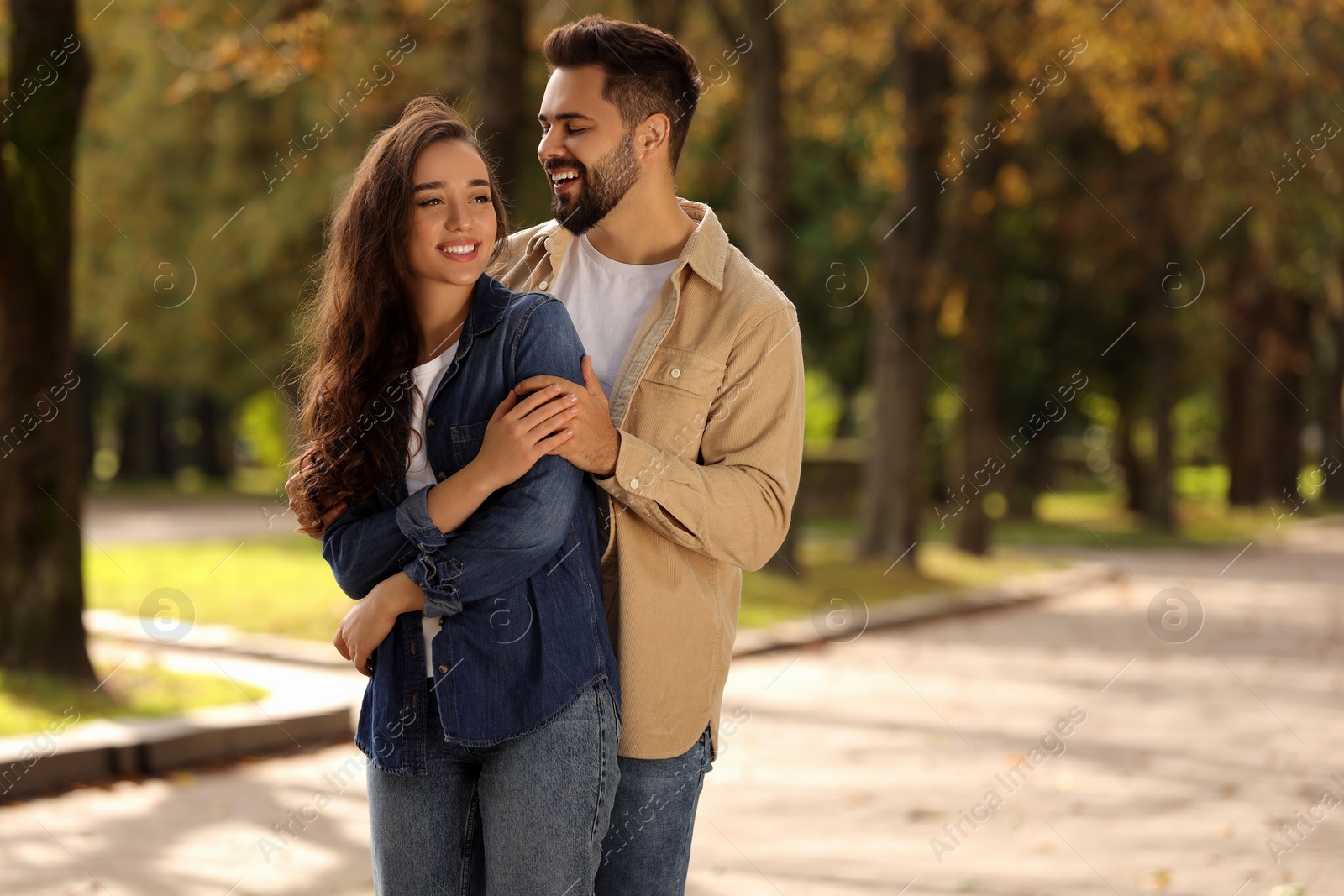 Photo of Beautiful couple spending time together in autumn park, space for text