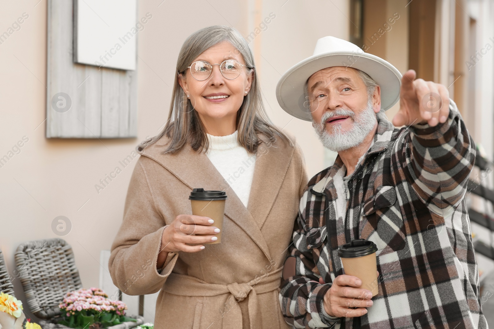 Photo of Affectionate senior couple drinking coffee outdoors, space for text