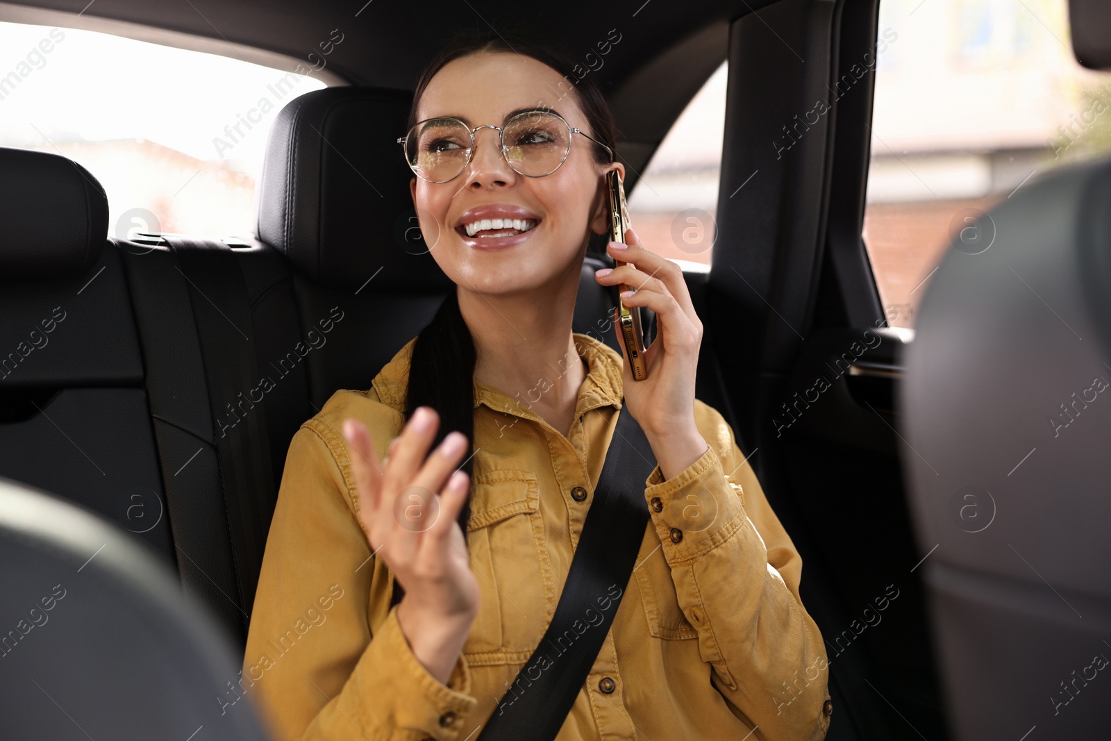 Photo of Woman with seatbelt talking on phone inside car