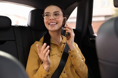 Photo of Woman with seatbelt talking on phone inside car