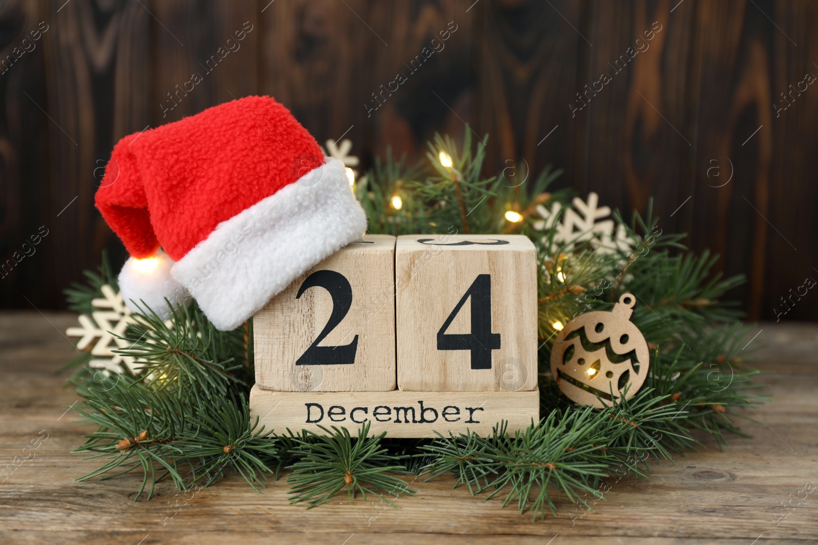 Photo of December 24 - Christmas Eve. Wooden block calendar and festive decor on table