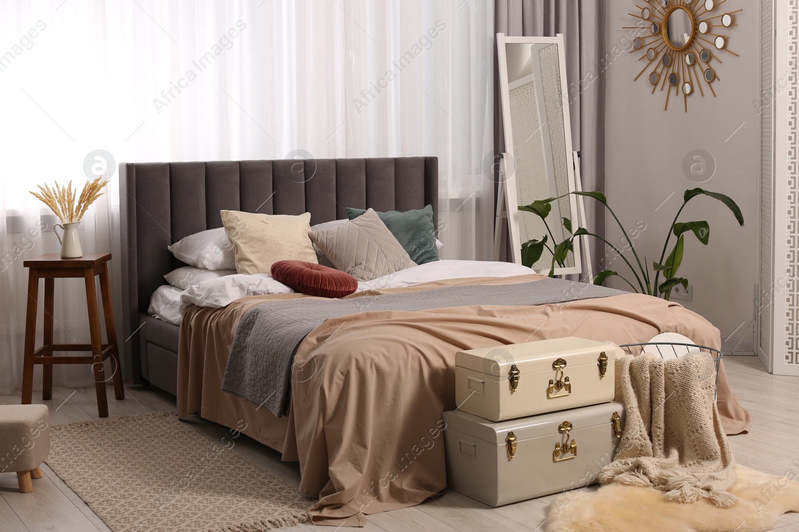 Photo of Large comfortable bed with soft pillows and blankets in room. Home textile