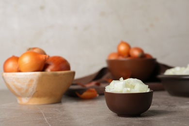 Photo of Small bowl with cut onion on table