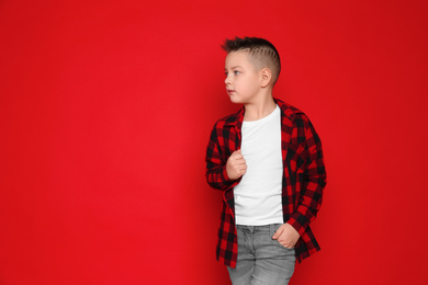 Photo of Portrait of cute little boy on red background. Space for text