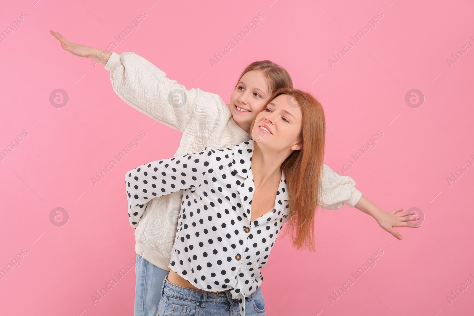 Photo of Happy mother with her cute daughter on pink background