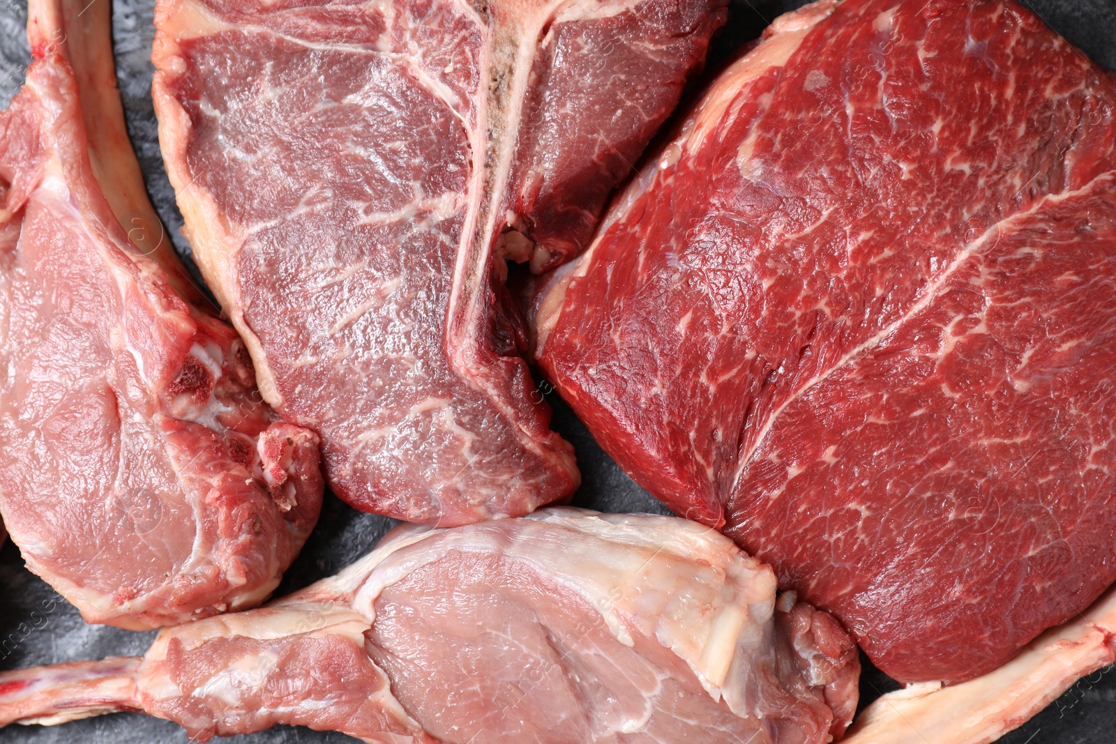 Photo of Fresh raw beef cuts on table, top view