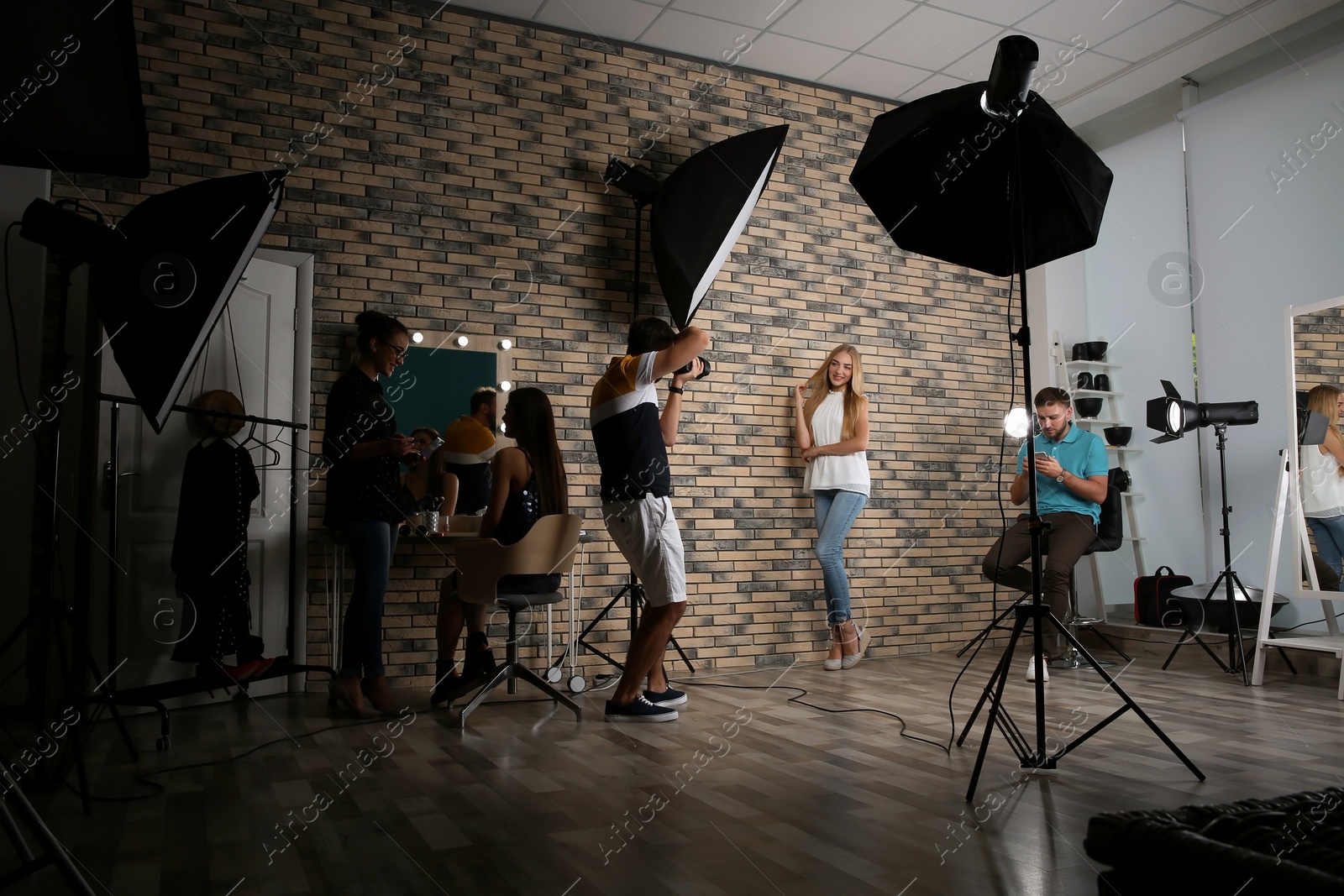 Photo of Professional team working with model in photo studio