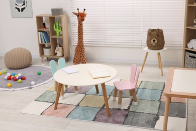 Photo of Stylish kindergarten interior with toys and modern furniture