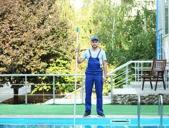 Photo of Male worker cleaning outdoor pool with scoop net