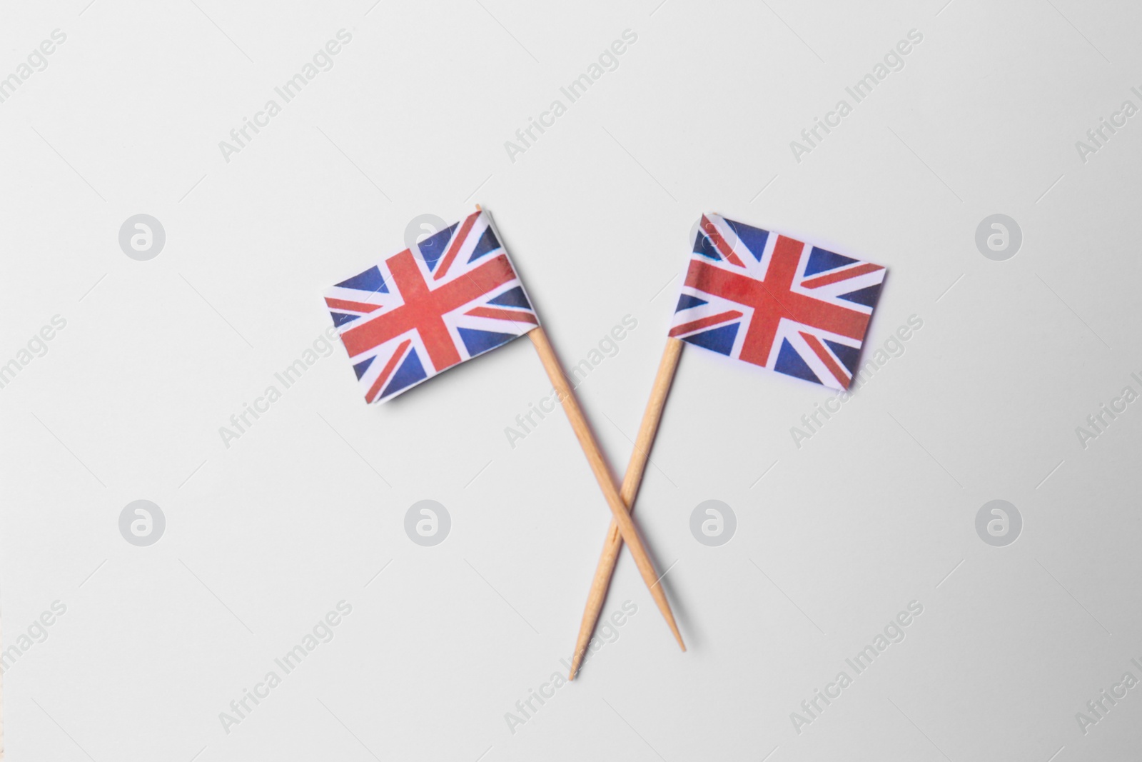 Photo of Small paper flags of United Kingdom on light background, flat lay