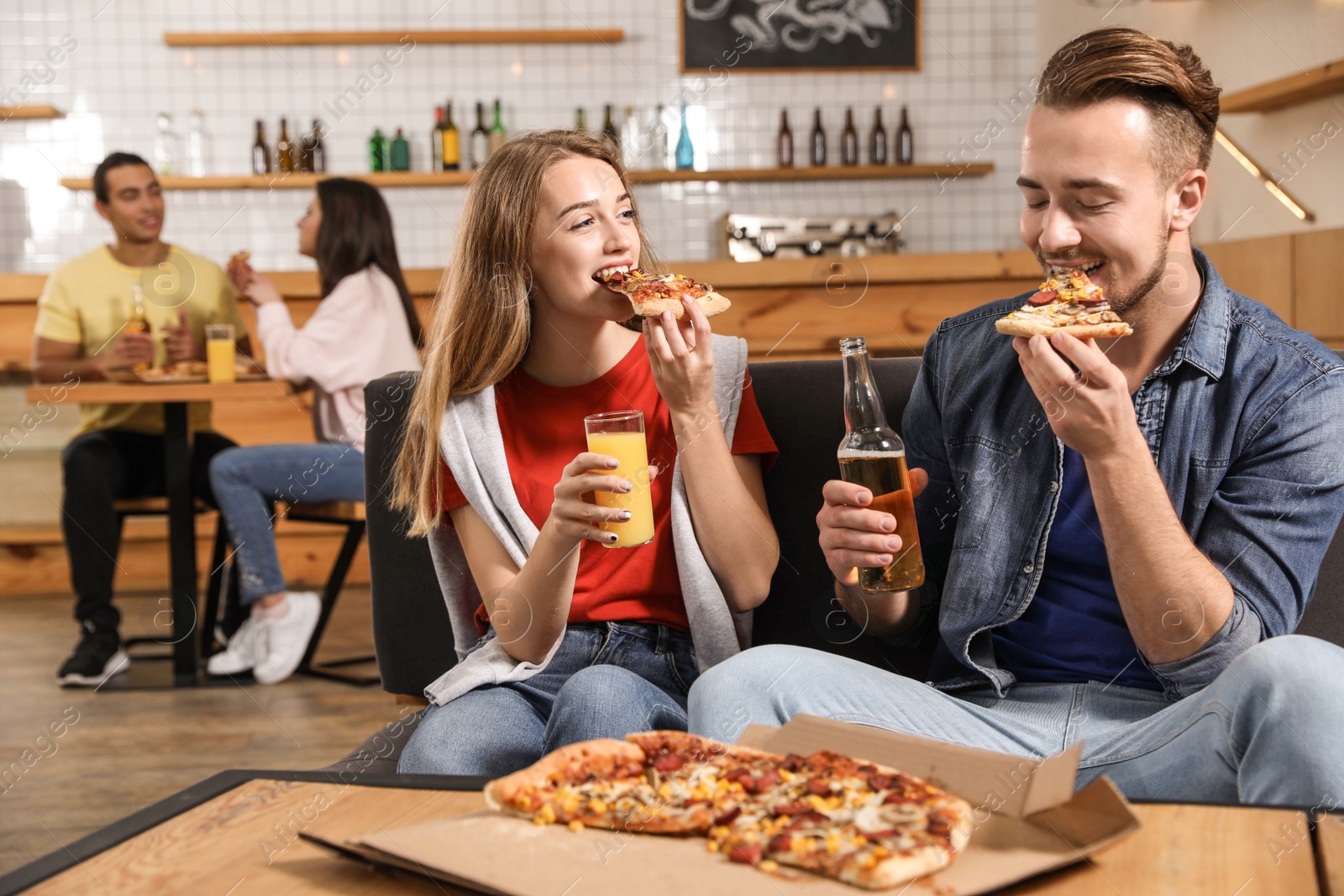 Photo of Young couple eating delicious pizza in cafe