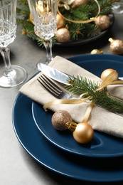 Festive table setting with beautiful dishware and Christmas decor on grey background