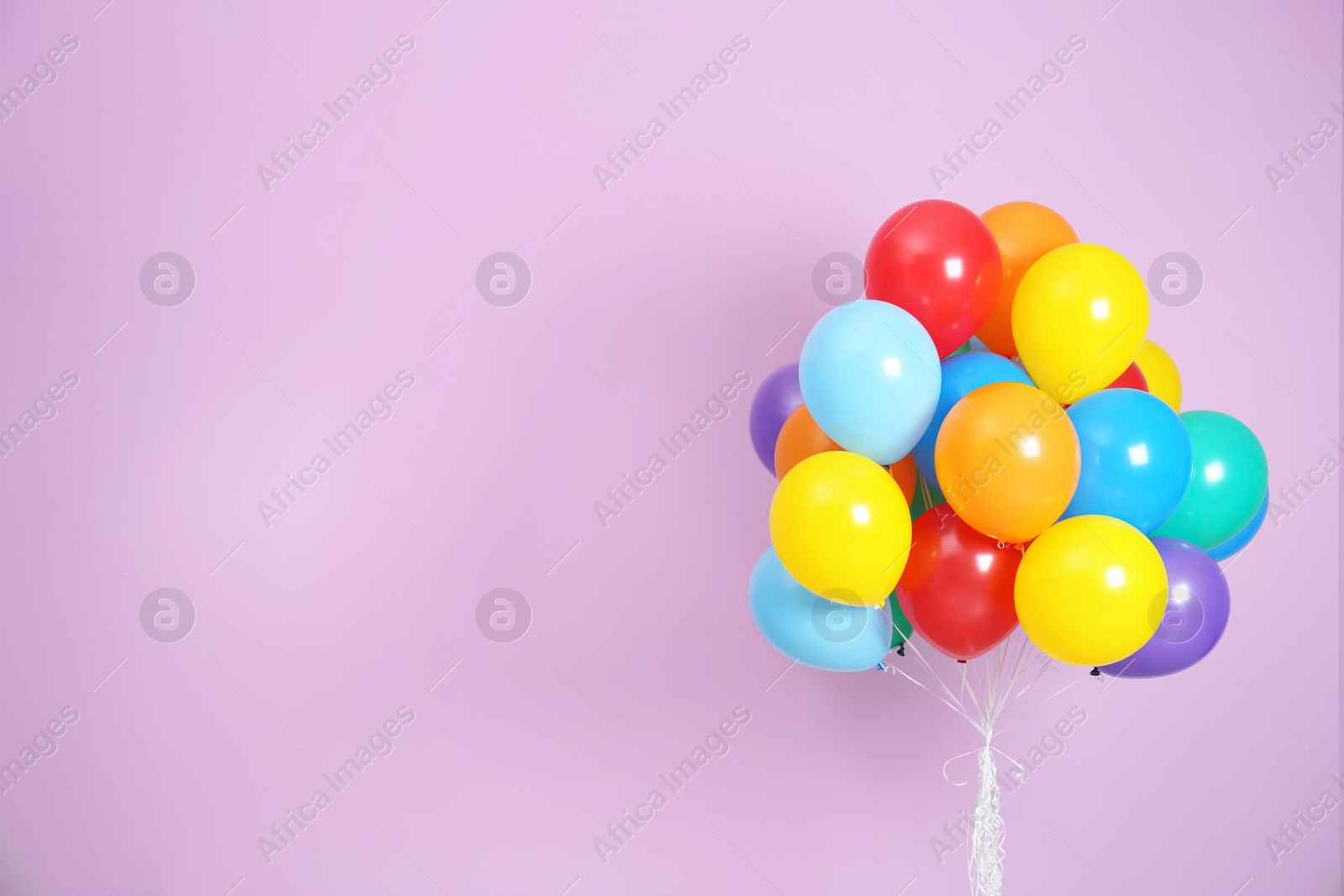 Photo of Bunch of bright balloons and space for text against color background