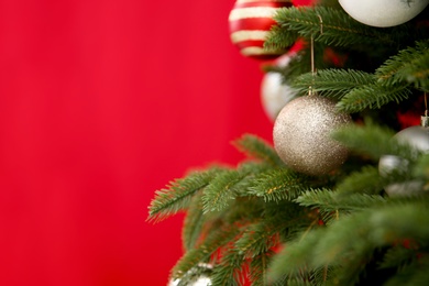 Beautifully decorated Christmas tree against color background, closeup