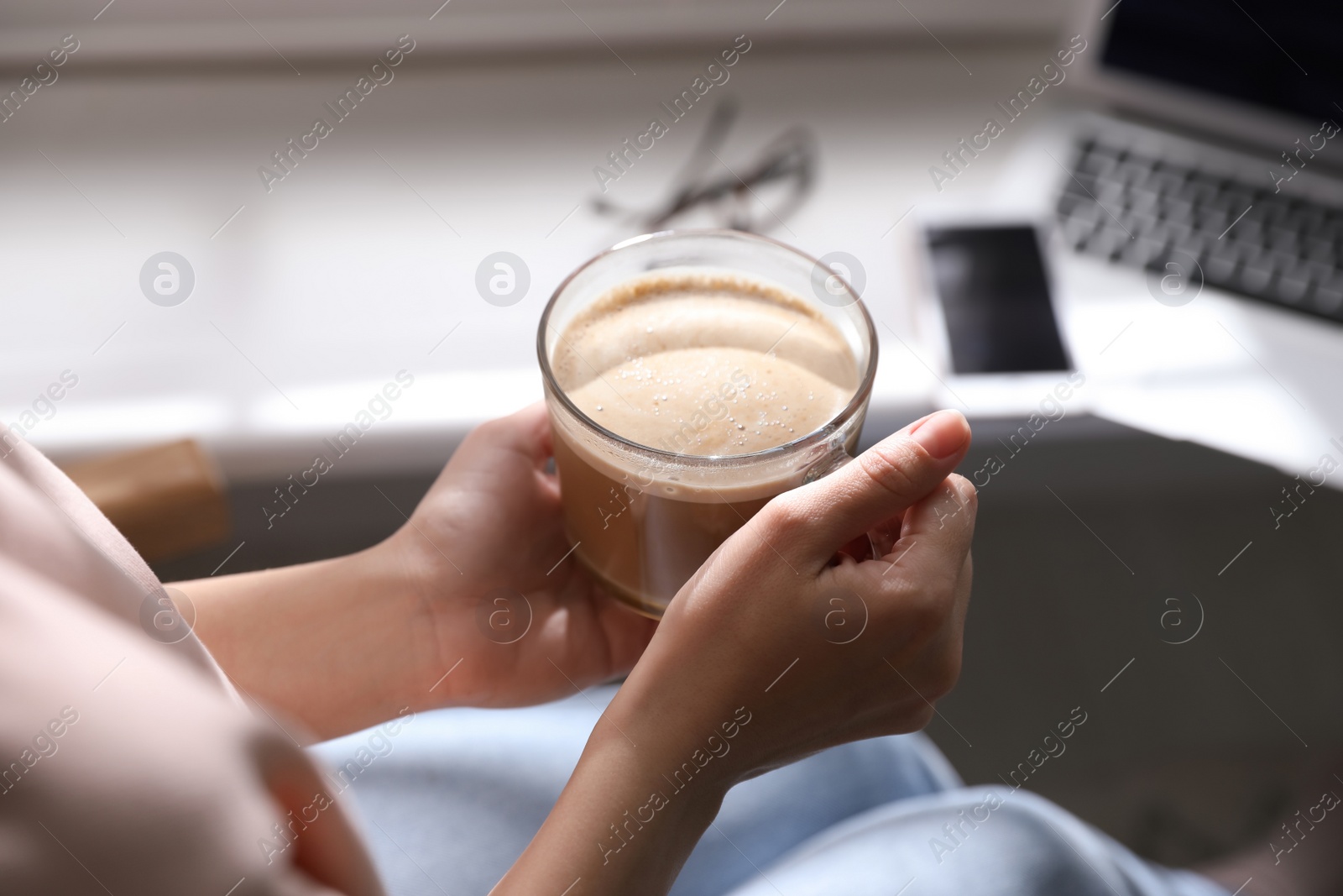 Photo of Woman with cup of coffee indoors, closeup