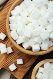 Photo of White sugar cubes on wooden table, top view
