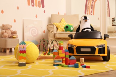 Photo of Child's electric car and other toys in playroom
