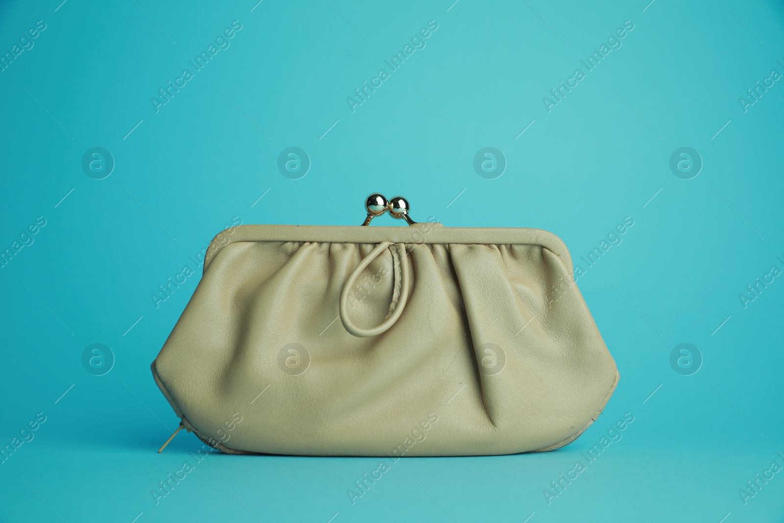 Photo of One stylish leather purse on light blue background