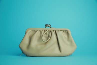 One stylish leather purse on light blue background