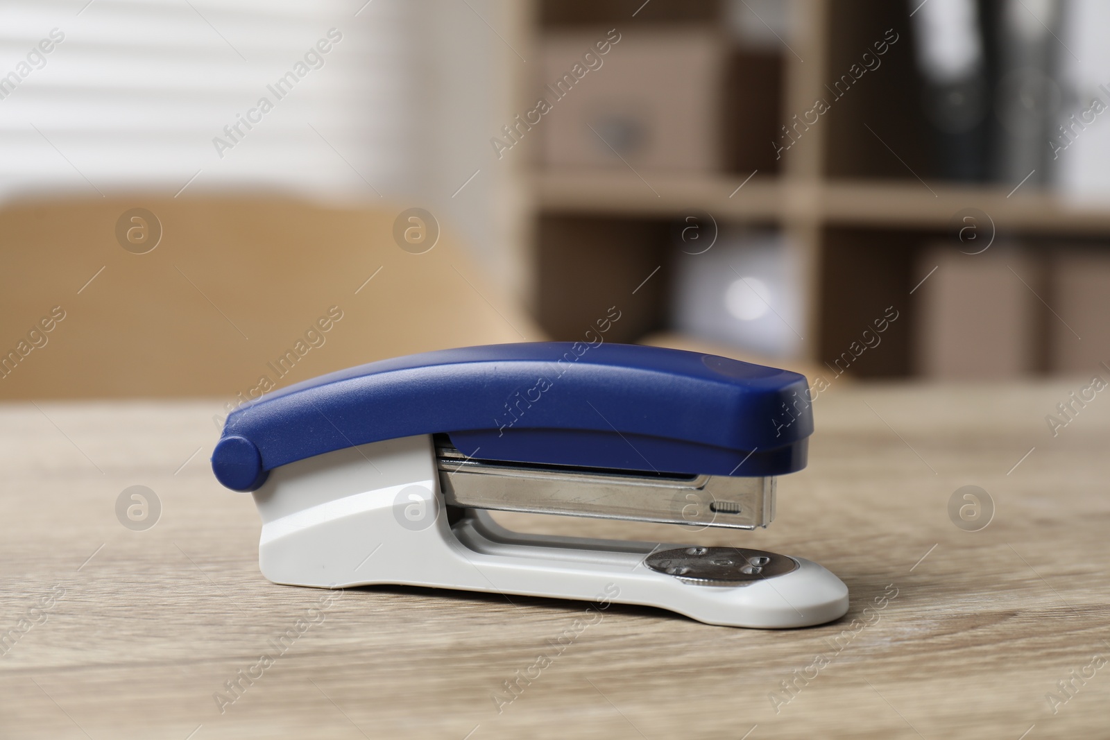 Photo of Bright stapler on wooden table indoors, closeup