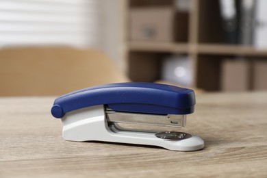 Photo of Bright stapler on wooden table indoors, closeup