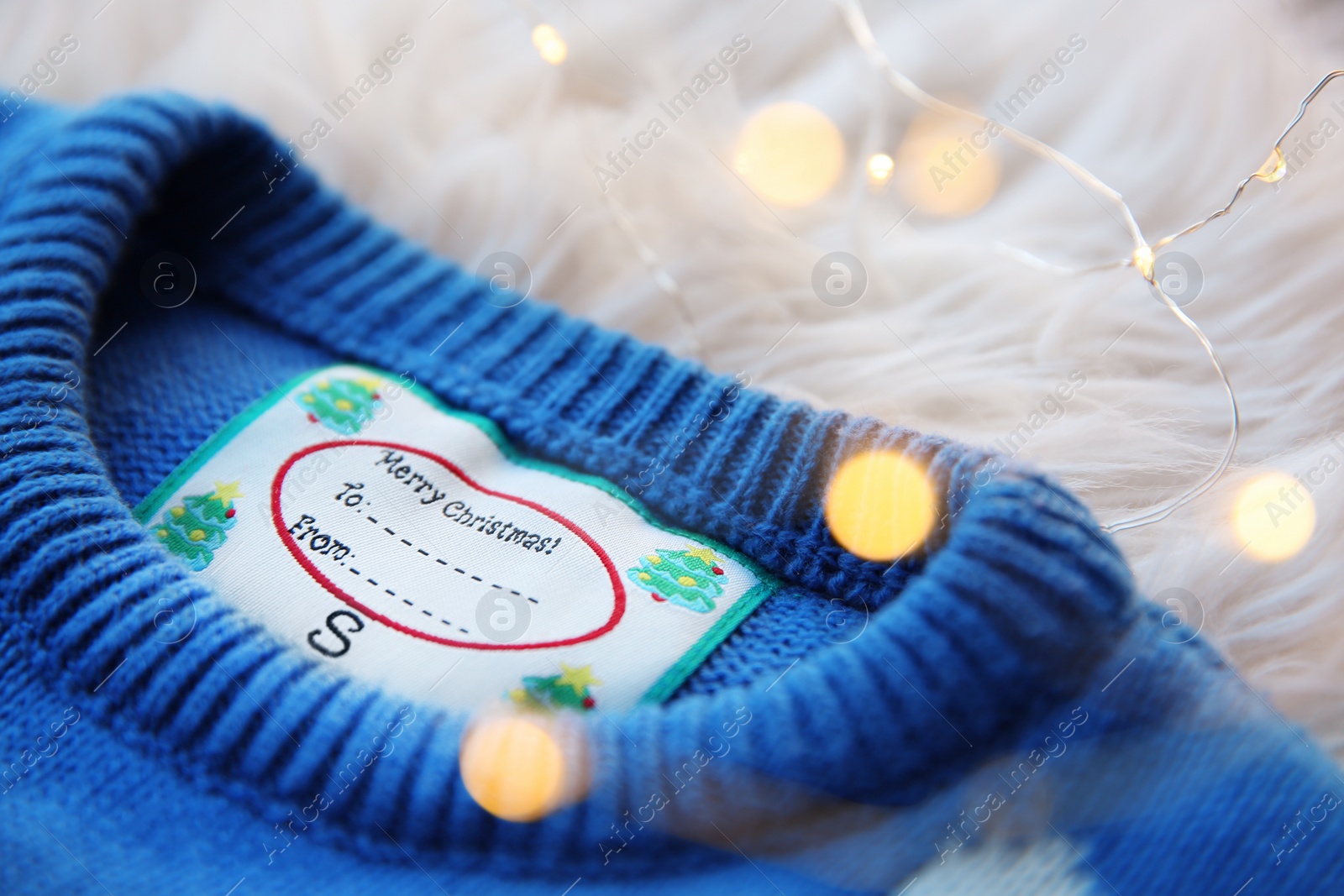 Photo of Christmas sweater with tag on fur, closeup