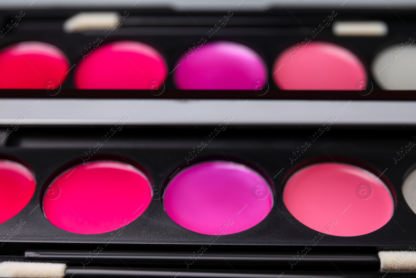 Photo of Cream lipstick palette with brush as background, closeup. Professional cosmetic product