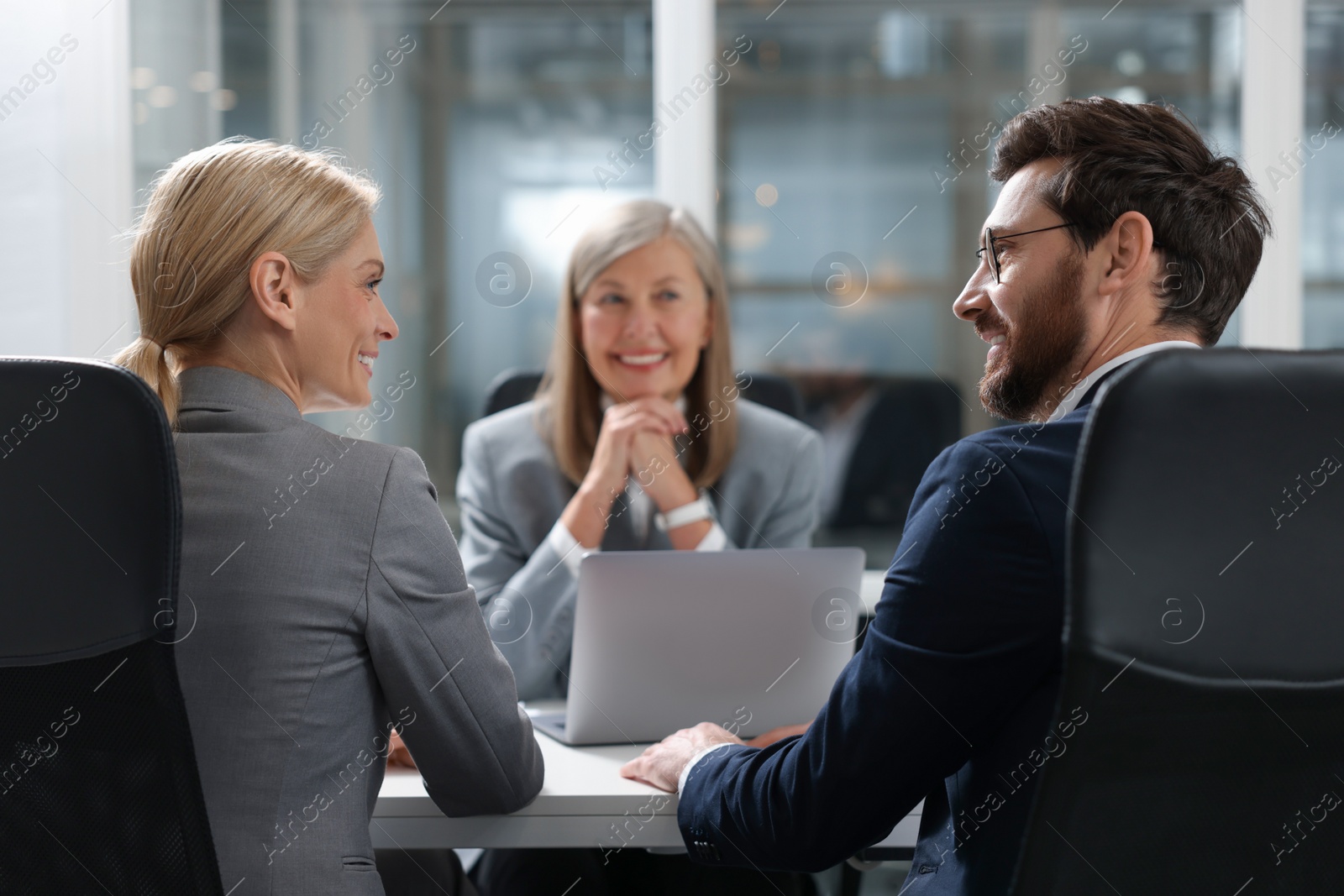 Photo of Lawyer working with clients at table in office