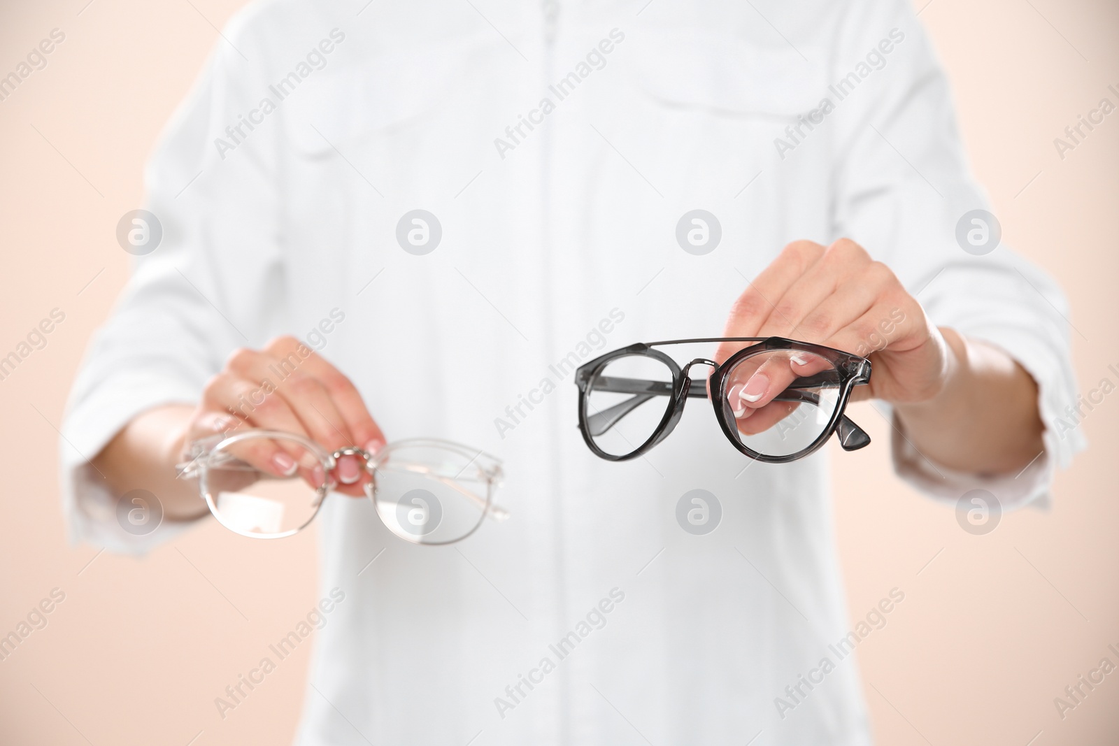 Photo of Female ophthalmologist with eyeglasses on light background, closeup