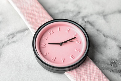 Photo of Stylish wrist watch on marble background, closeup. Fashion accessory
