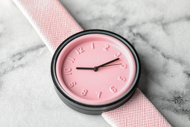 Stylish wrist watch on marble background, closeup. Fashion accessory