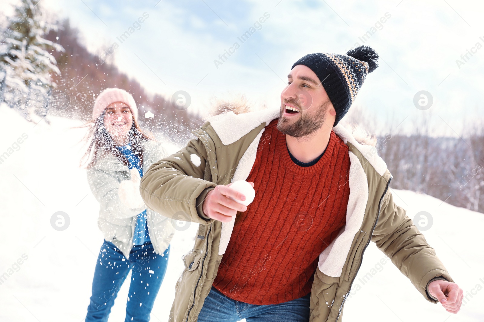 Photo of Happy couple playing snowballs outdoors. Winter vacation