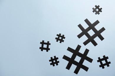 Photo of Paper hashtag symbols on light grey background, flat lay. Space for text