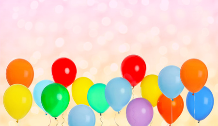 Bright balloons on color background with bokeh effect, space for text. Banner design