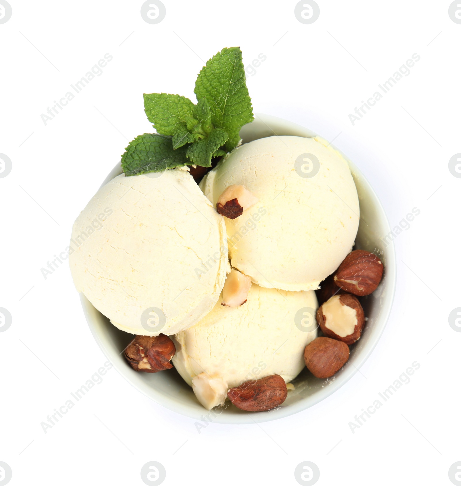 Photo of Delicious vanilla ice cream with hazelnuts and mint in dessert bowl on white background, top view