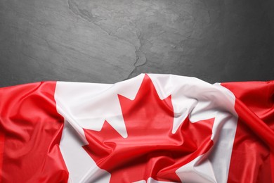 Photo of Flag of Canada on black background, top view. Space for text