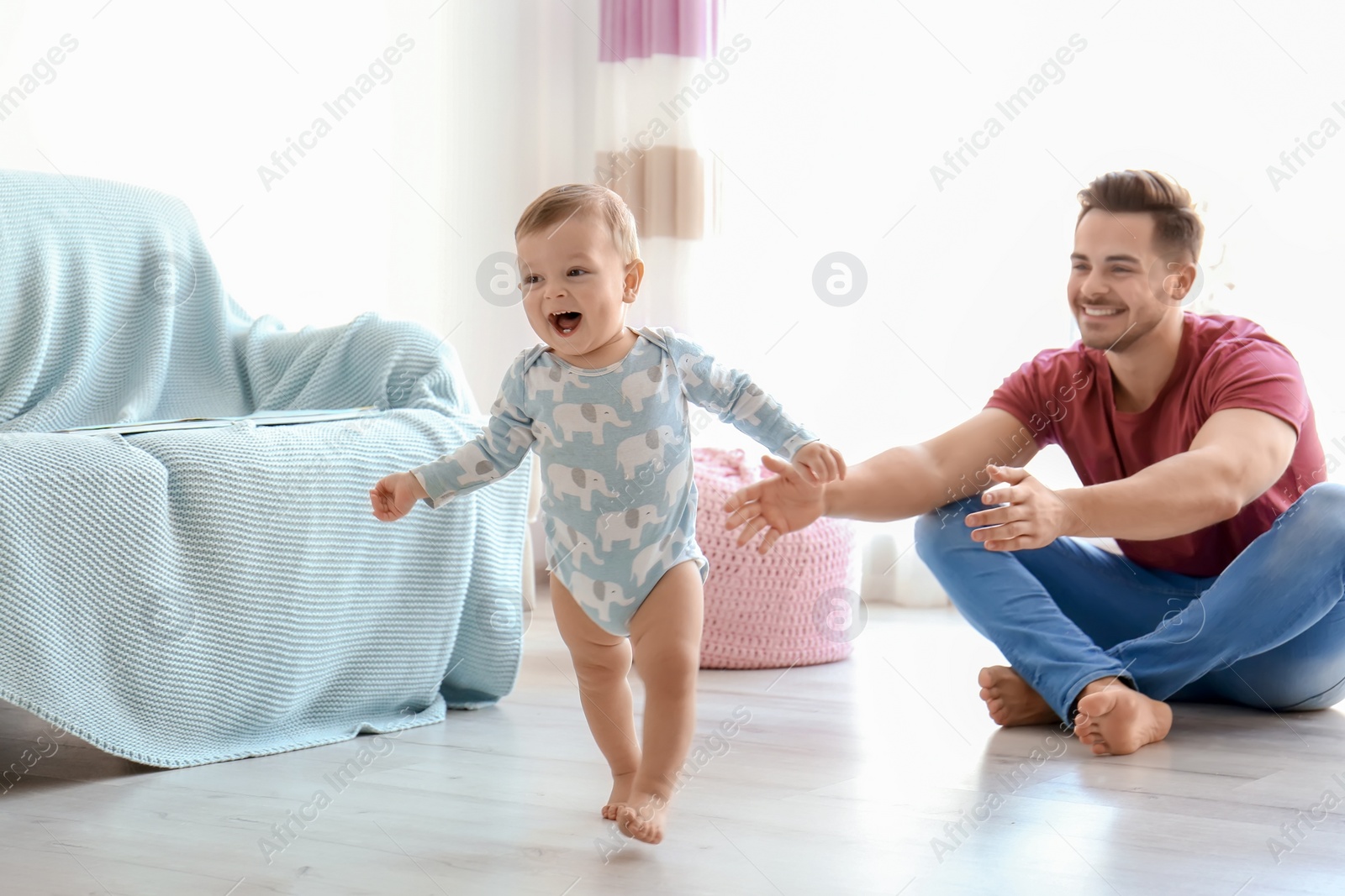 Photo of Baby taking first steps with father's help at home