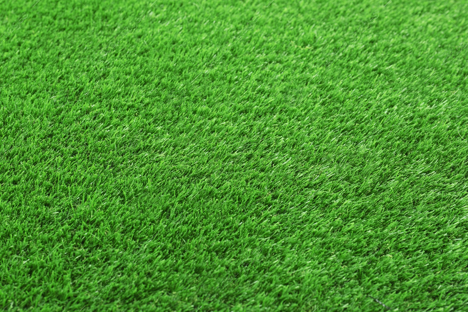 Photo of Artificial grass carpet as background, closeup. Exterior element