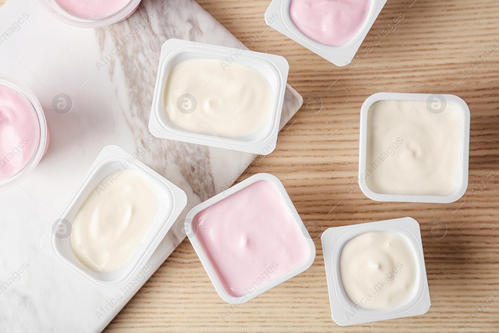 Photo of Plastic cups with tasty yogurt on table, top view