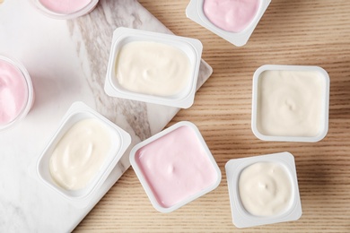 Plastic cups with tasty yogurt on table, top view