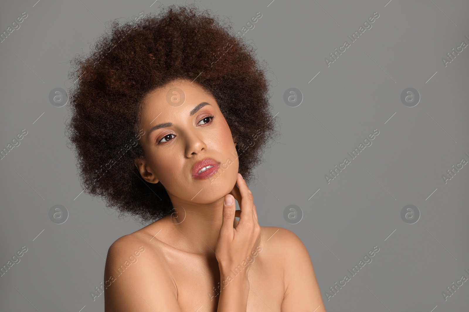 Photo of Portrait of beautiful young woman with glamorous makeup on grey background. Space for text