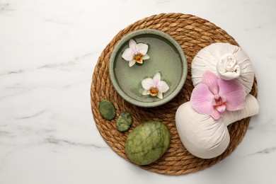 Composition with spa products and flowers on white marble table, top view. Space for text