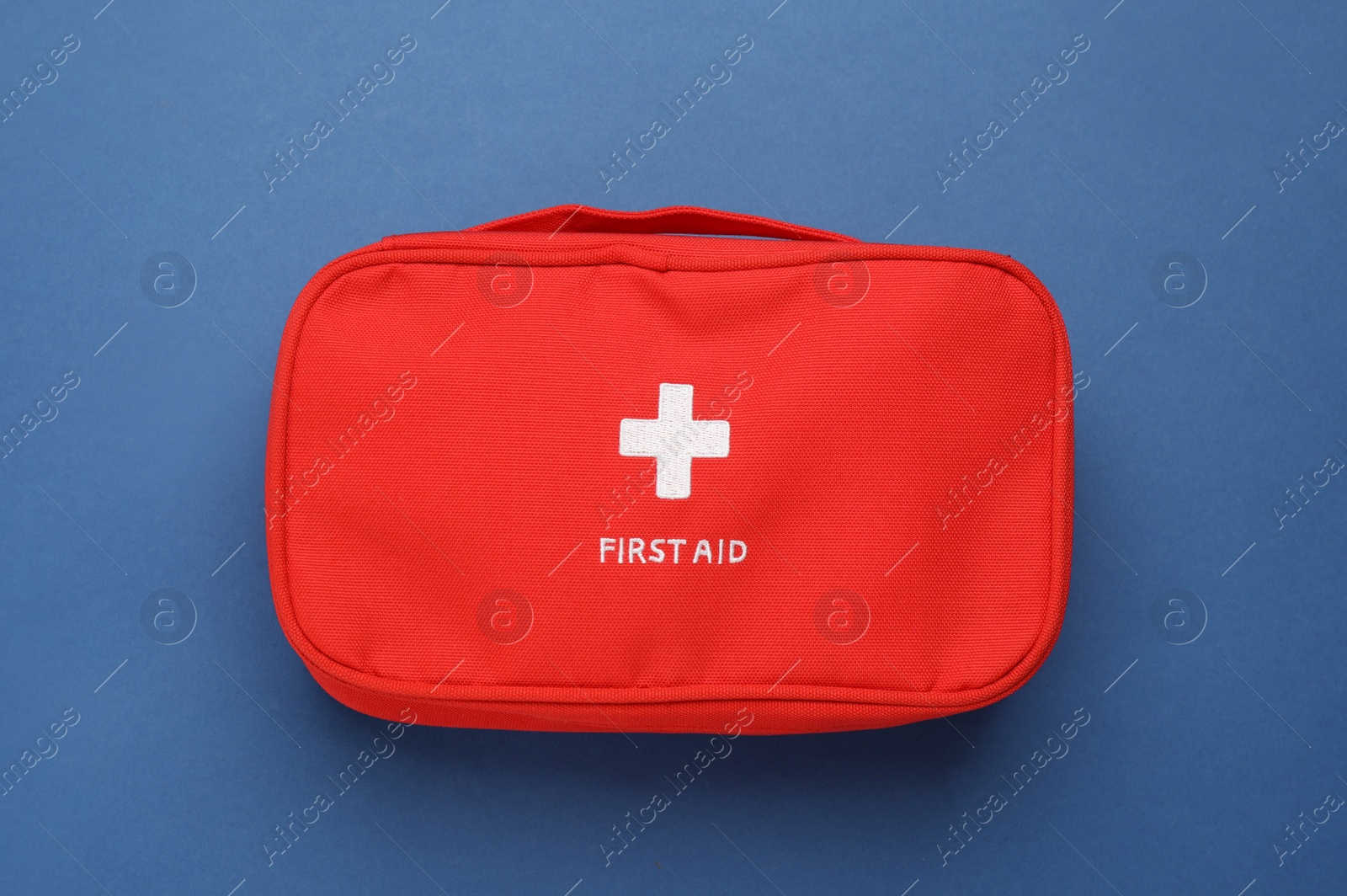 Photo of First aid kit bag on blue background, top view