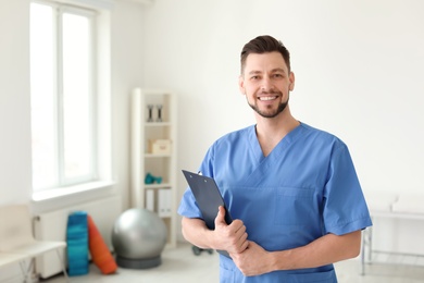 Young physiotherapist with clipboard in rehabilitation center