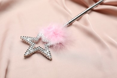 Photo of Beautiful silver magic wand with feather on pink fabric