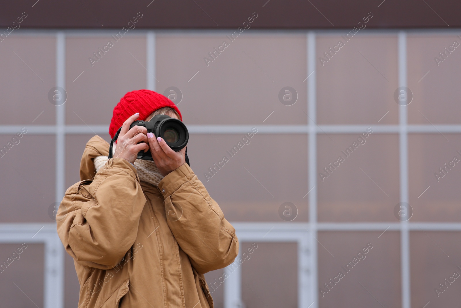 Photo of Photographer taking photo with professional camera outdoors. Space for text