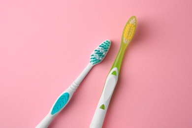 New toothbrushes on pink background, flat lay