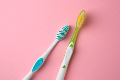 Photo of New toothbrushes on pink background, flat lay