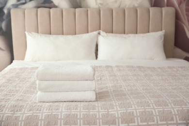 Photo of Clean white towels on bed at home