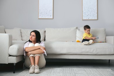 Photo of Depressed single mother with child in living room